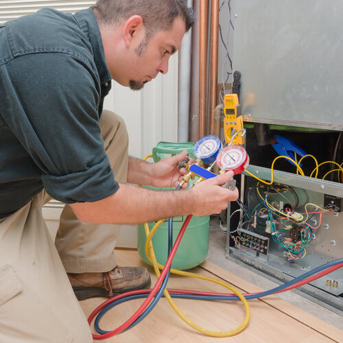 HVAC technician charging a heat pump with refrigerant