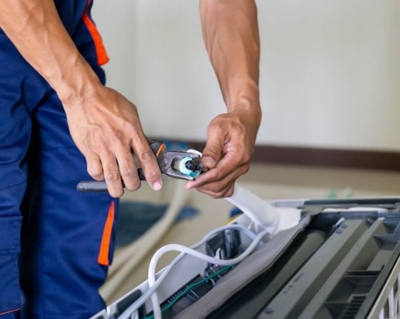 HVAC man fixing HVAC unit - close up of hands with pliers