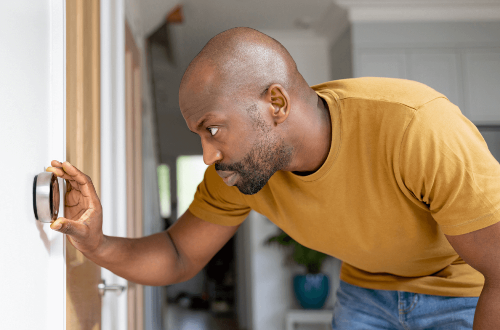 man adjusting thermostat