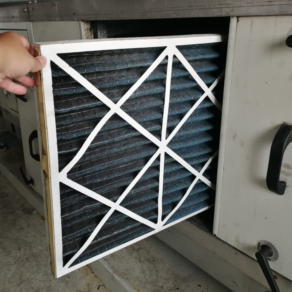 Technician checking a Pre-filter of air handling unit for replacement a new filter - HVAC maintenance