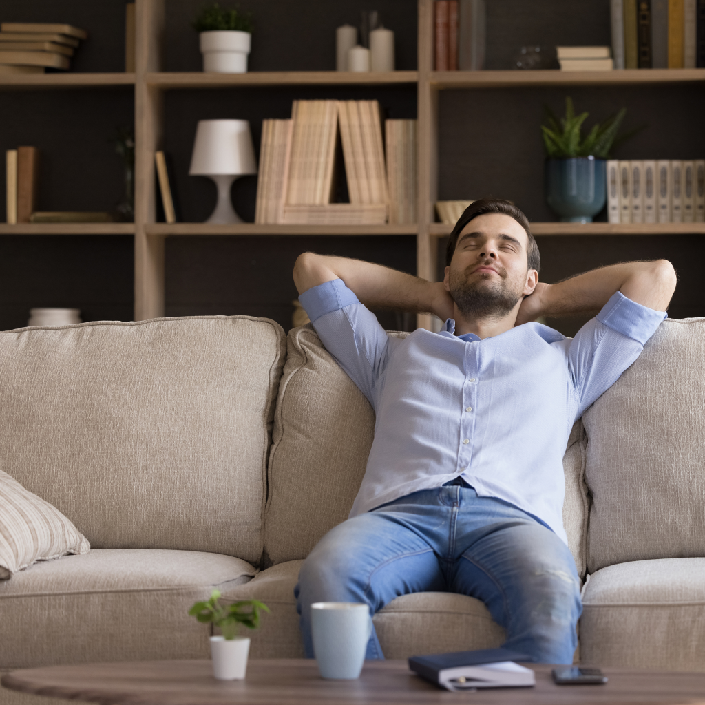 Peaceful millennial man relaxing on couch