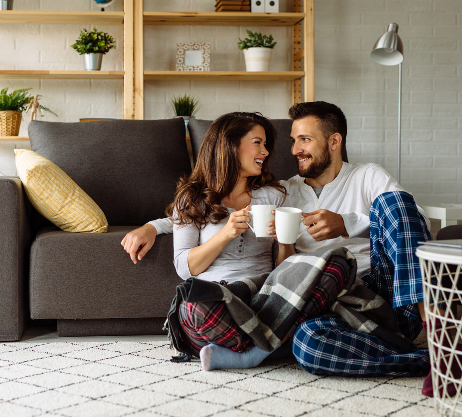 Loving couple relaxing at home with coffee mugs