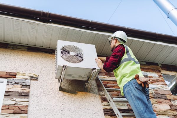 HVAC technician working on outside unit